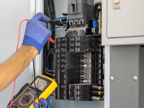 An electrician testing the electrical panel.