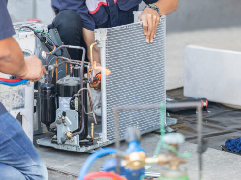 A team of technicians repairing an AC unit