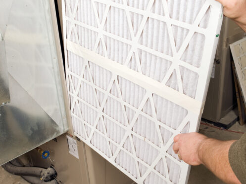 A man replacing a furnace filter in Palm Springs
