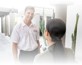 Technician speaking with a homeowner at the front entry of a house.